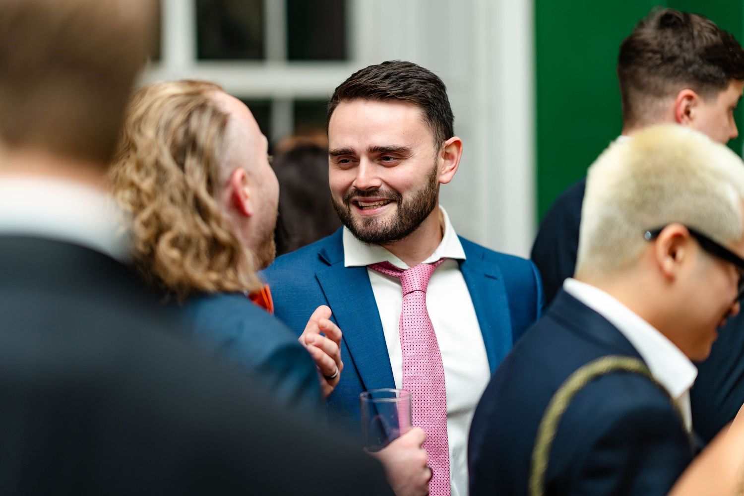 People in formal attire gather at what appears to be a social or business event.