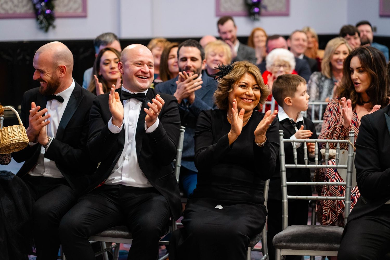 Wedding guests applaud and celebrate during reception festivities.