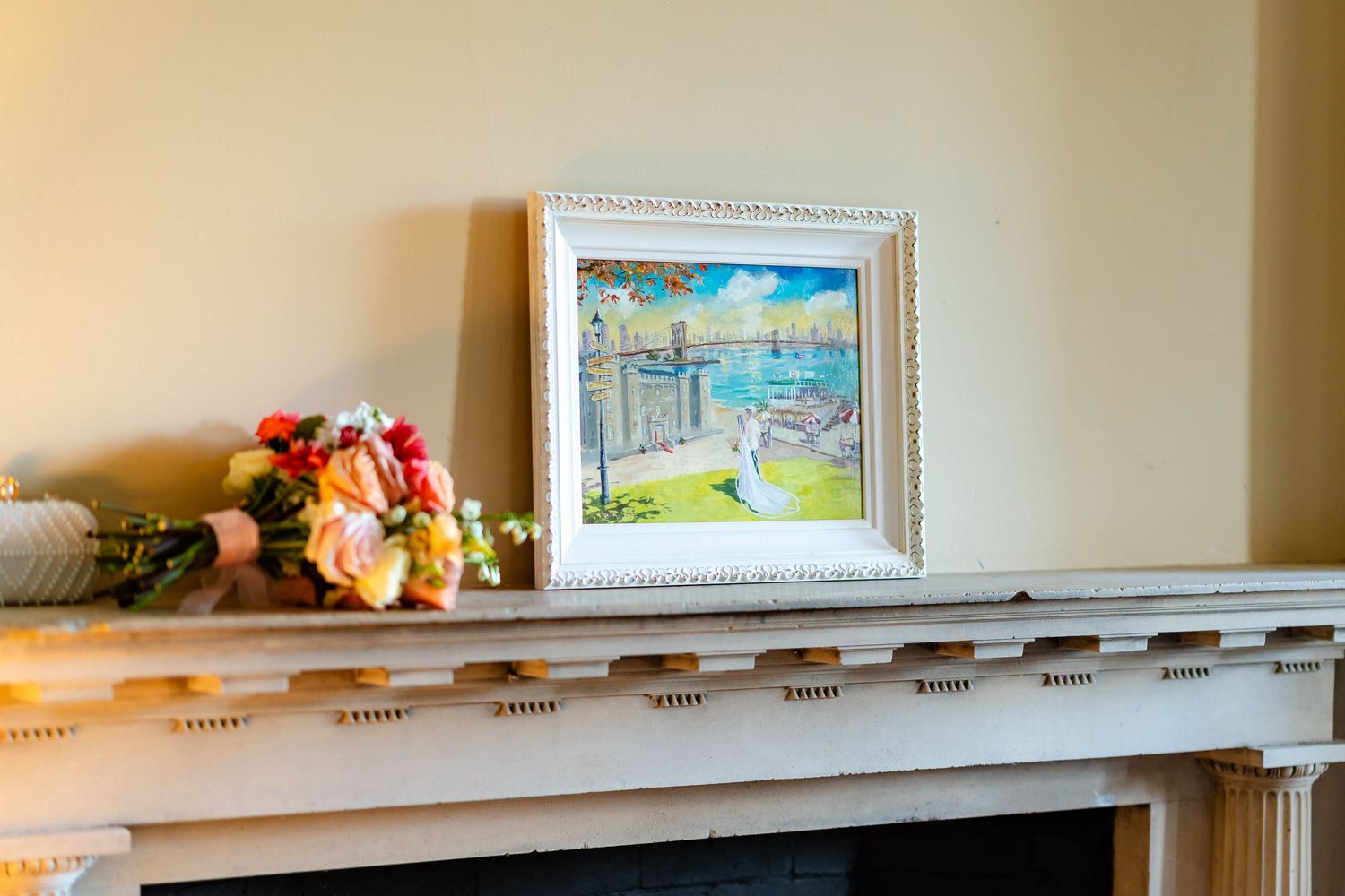 Decorative wall shelf displaying framed artwork and small ornamental items against a beige painted wall.