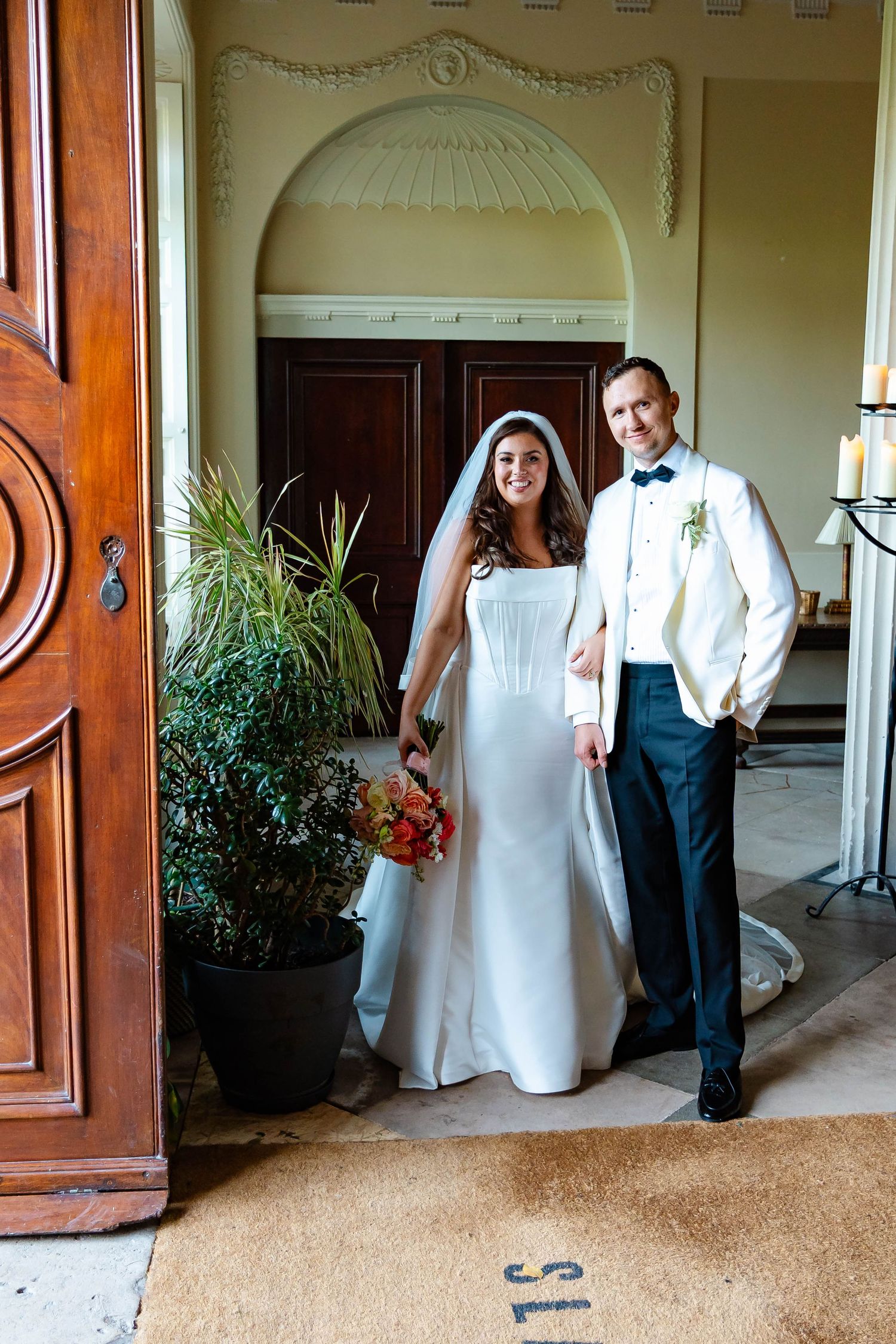 Wedding couple shares playful moments in a series of candid shots along an elegant hallway with potted plants.