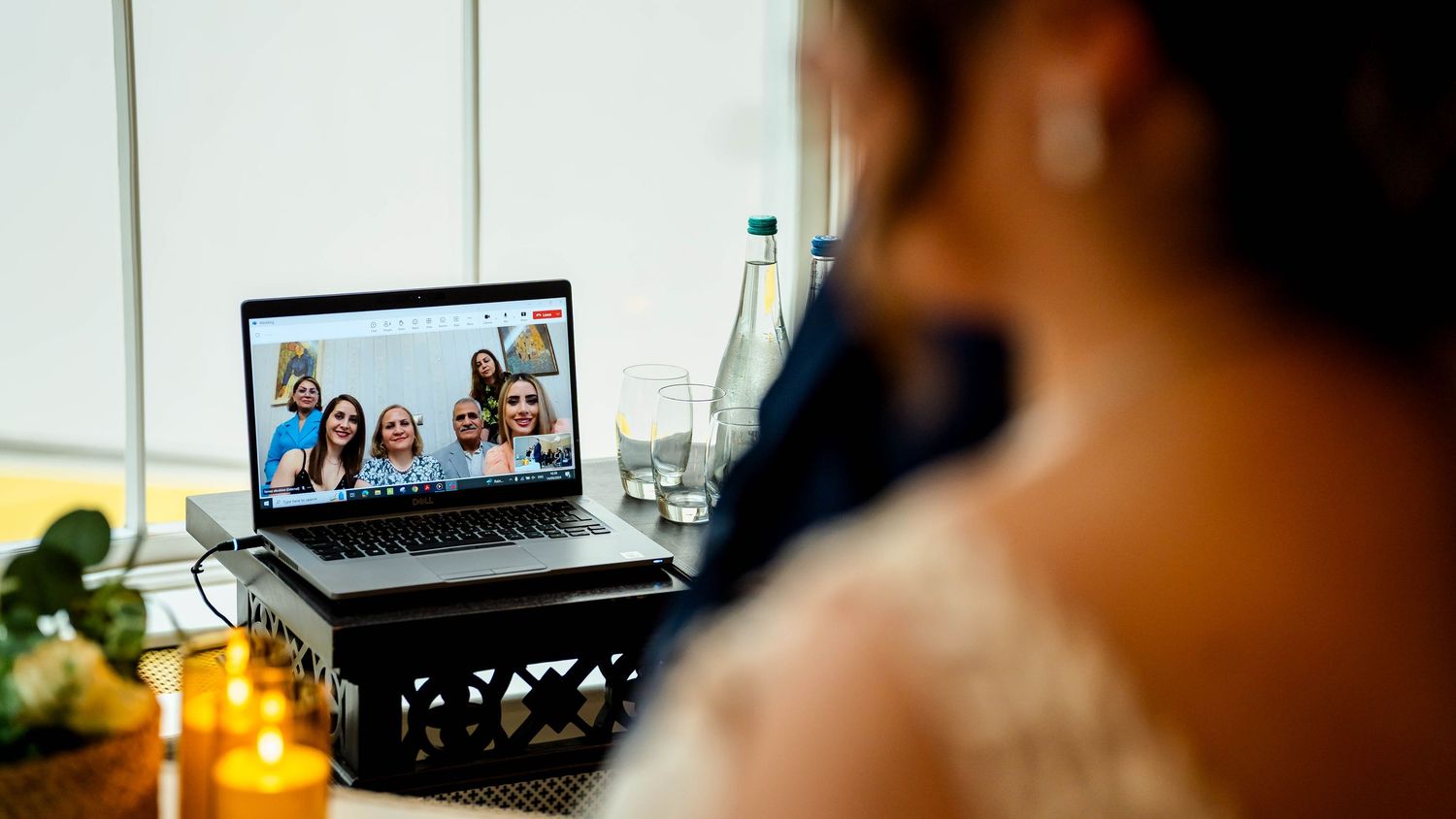 A row of video conference screens showing virtual wedding guests.
