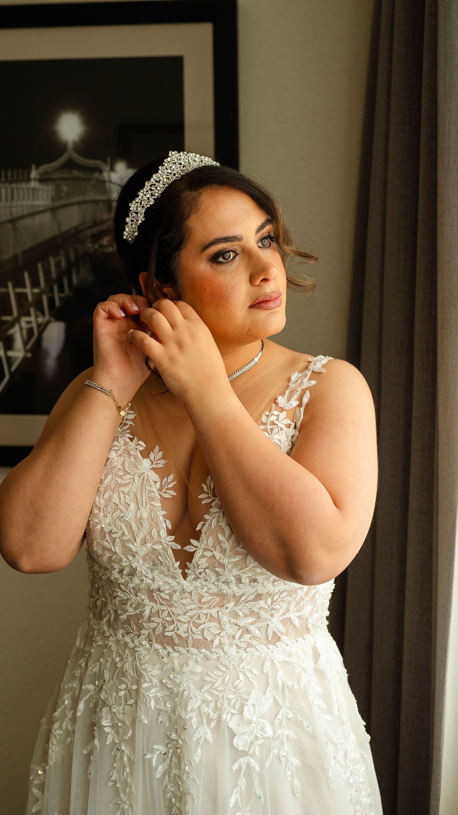 Close-up portrait of a bride in a lace wedding dress with delicate details and sparkling tiara.