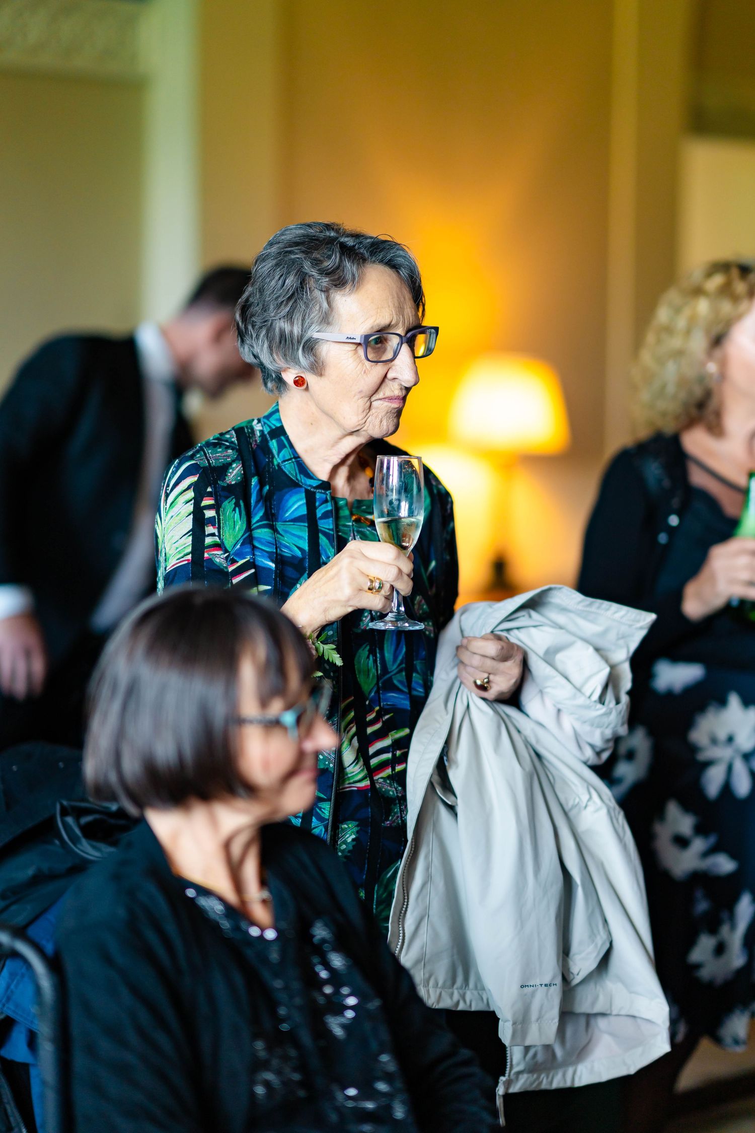 A person wearing glasses and a patterned shirt wipes their face with a napkin in a sequence of photos.