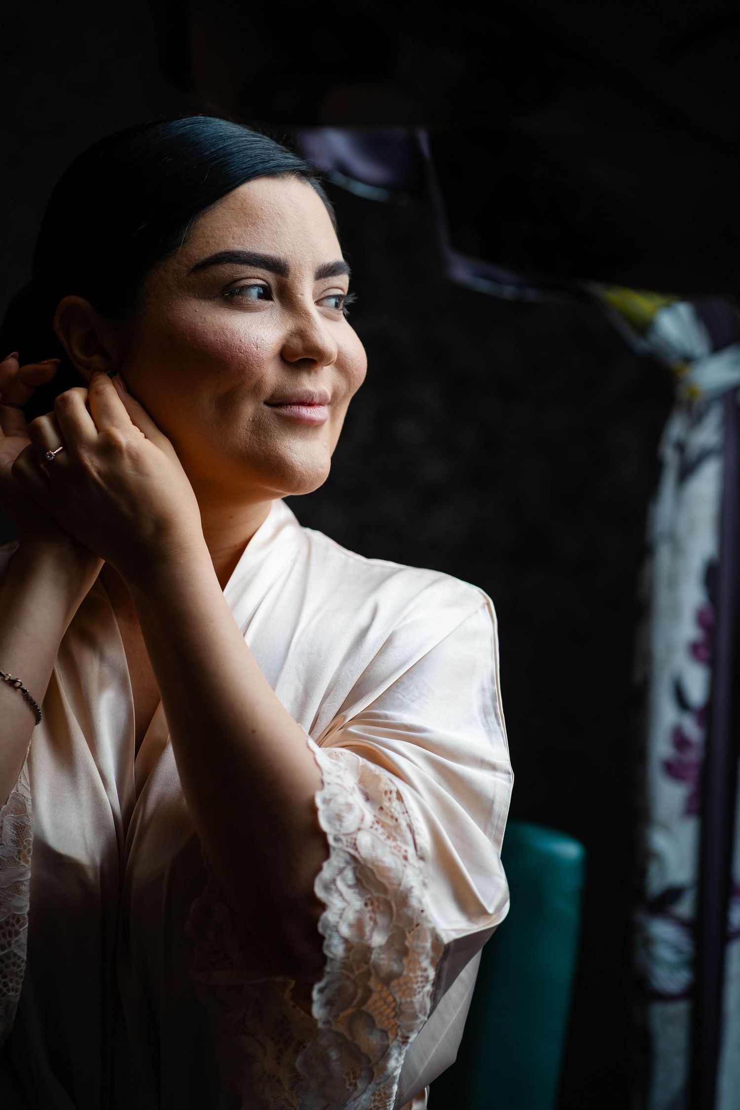 Side profile portrait in natural light showing person in white satin robe.