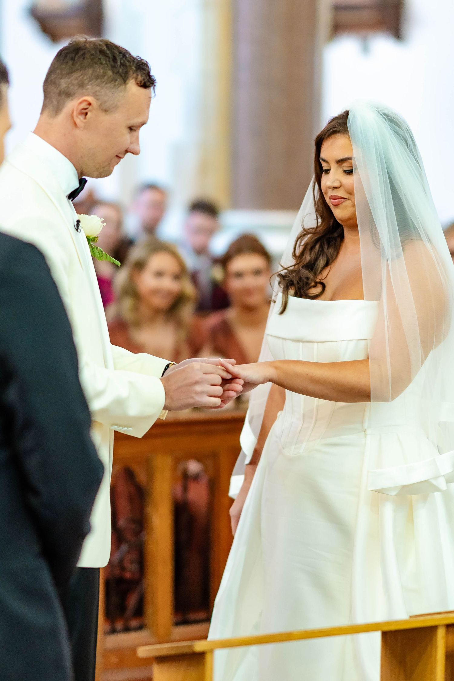 Close-up sequence of a bride and groom exchanging wedding rings during traditional church ceremony.