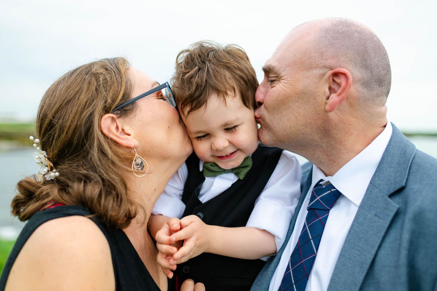 Candid moments of affection between wedding guests during an outdoor celebration.