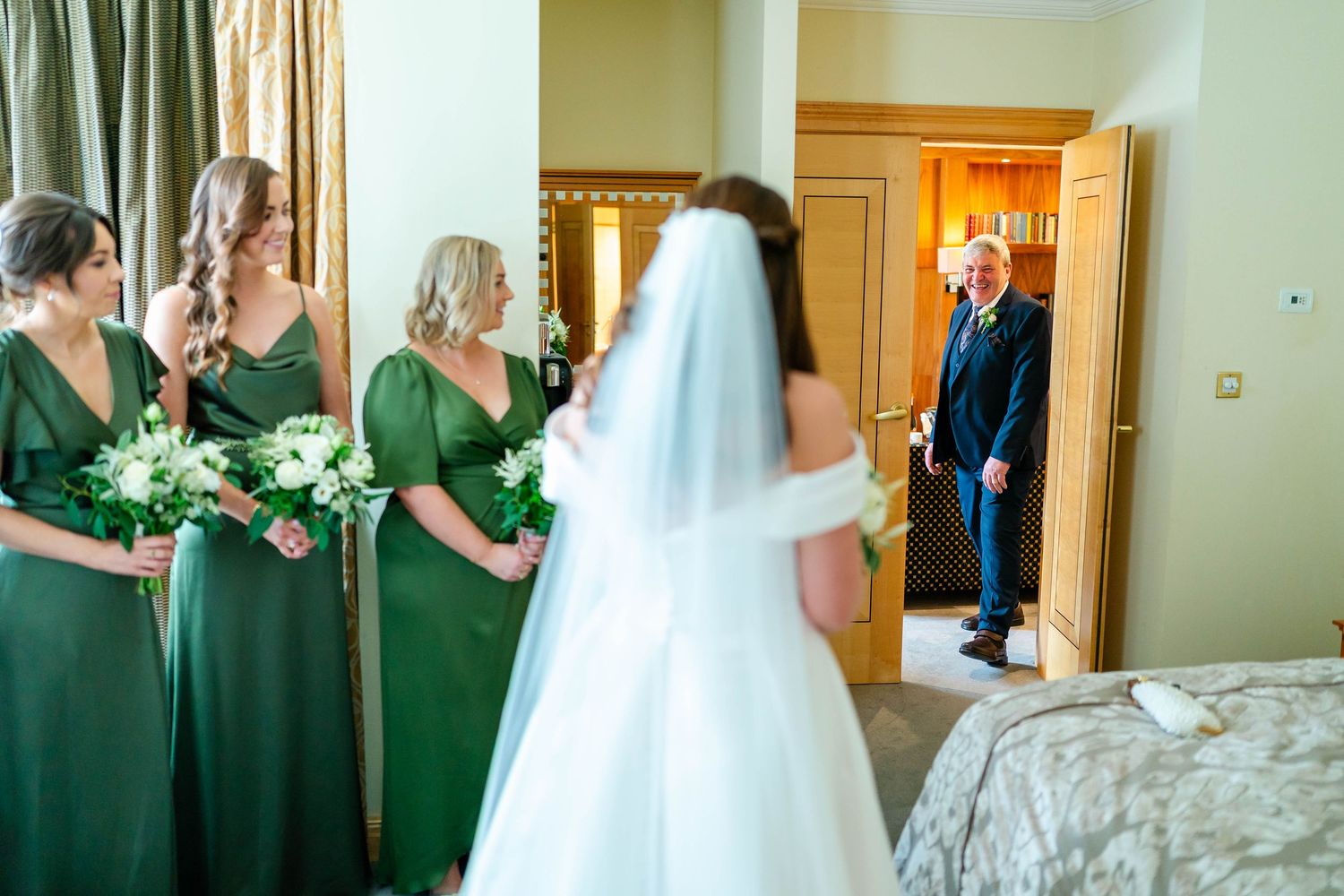 Wedding party members gather in a luxurious hotel hallway before the ceremony.