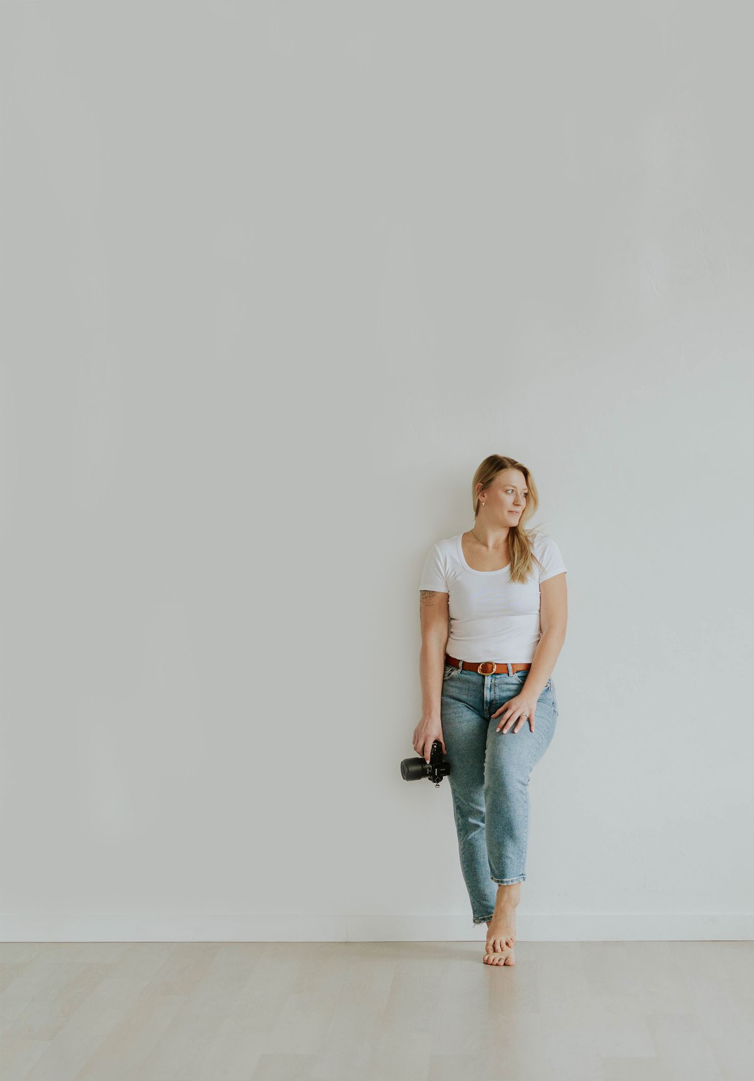 Minimalist fashion series showing someone in casual white top and jeans against plain white background in different poses.