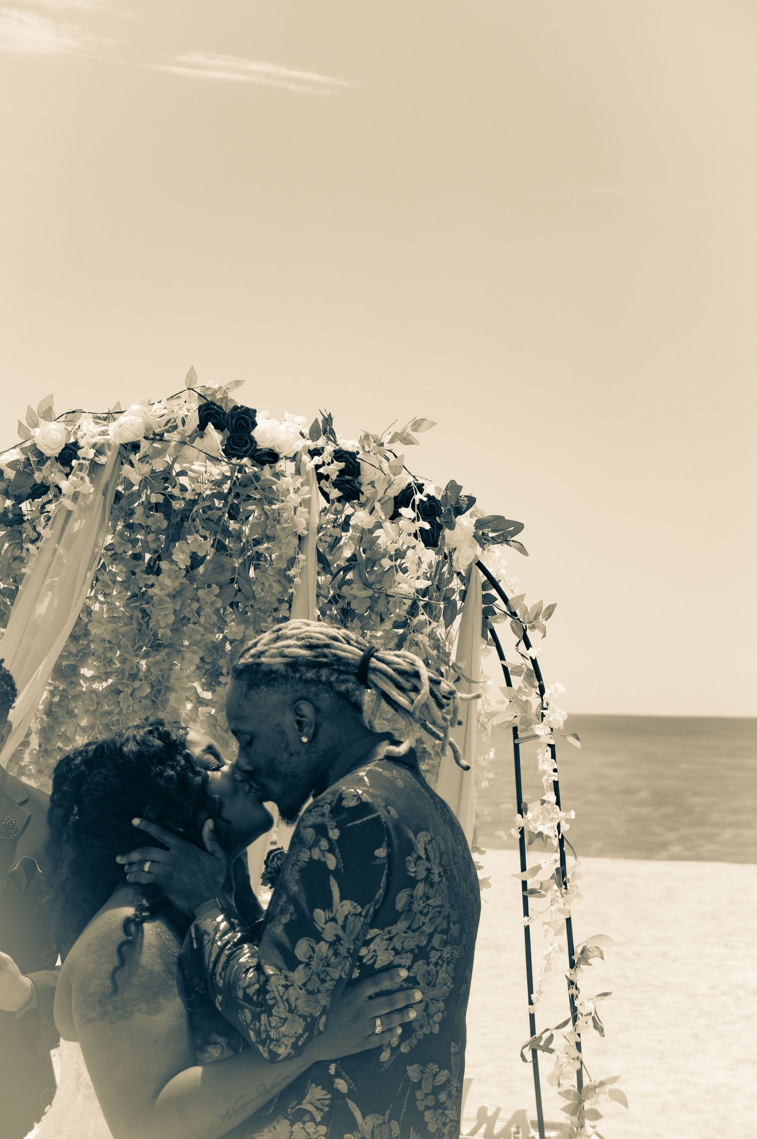 Bride and groom kissing with a tropical environment