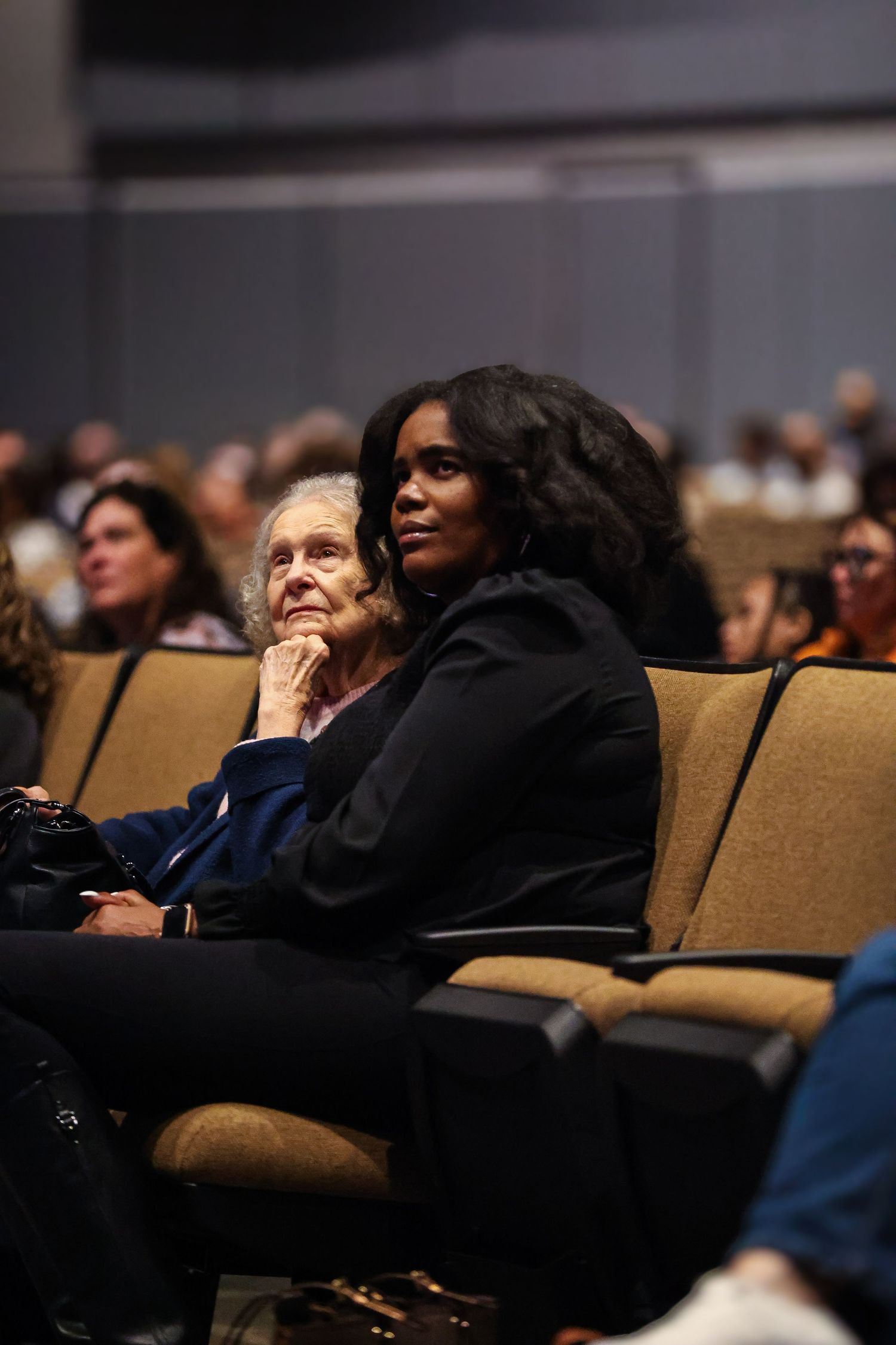Two women looking intently together during an event at church