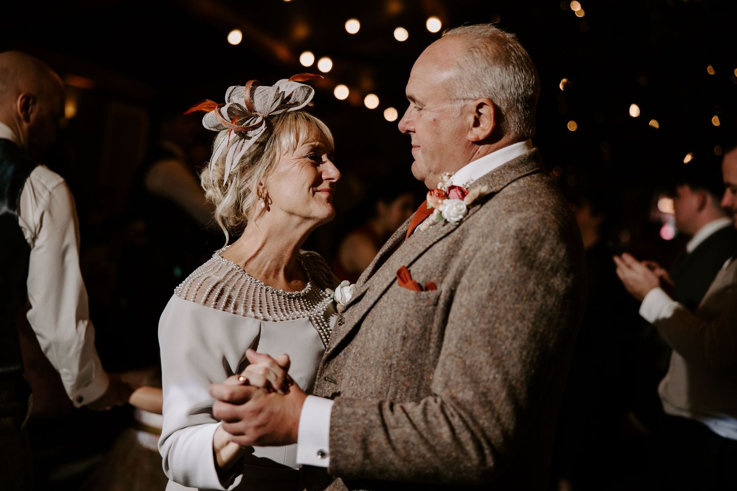 A series of black and white photos showing couples dancing and embracing at an elegant social gathering.