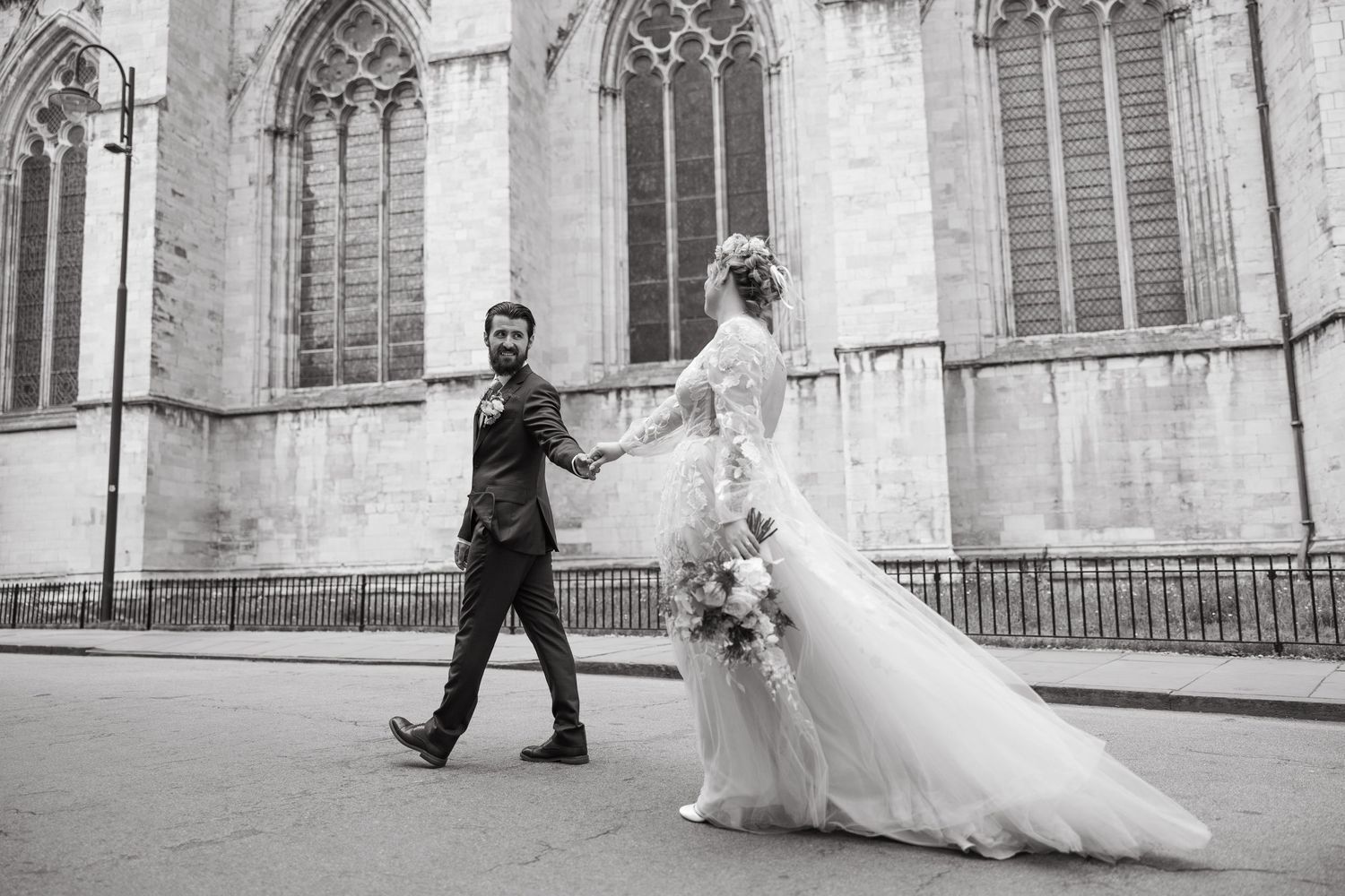 Elegant photo sequence showing a romantic couple's walk in front of a historic stone church facade.
