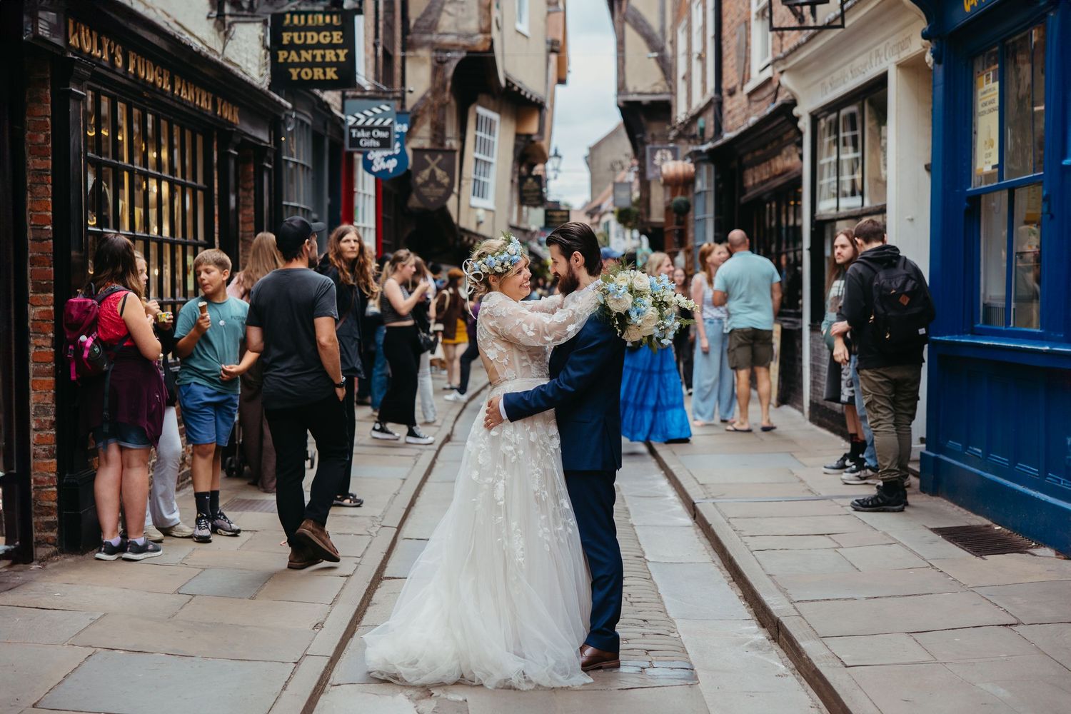 A wedding celebration on a charming cobblestone street lined with historic buildings in York.