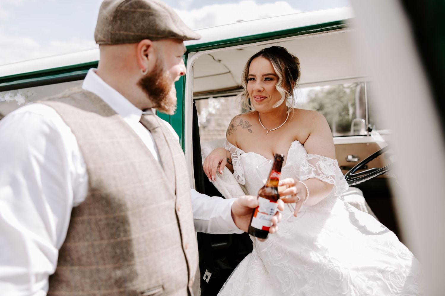 Couple toasts with glasses in a kitchen, sharing smiles and laughter during candid celebration moment.