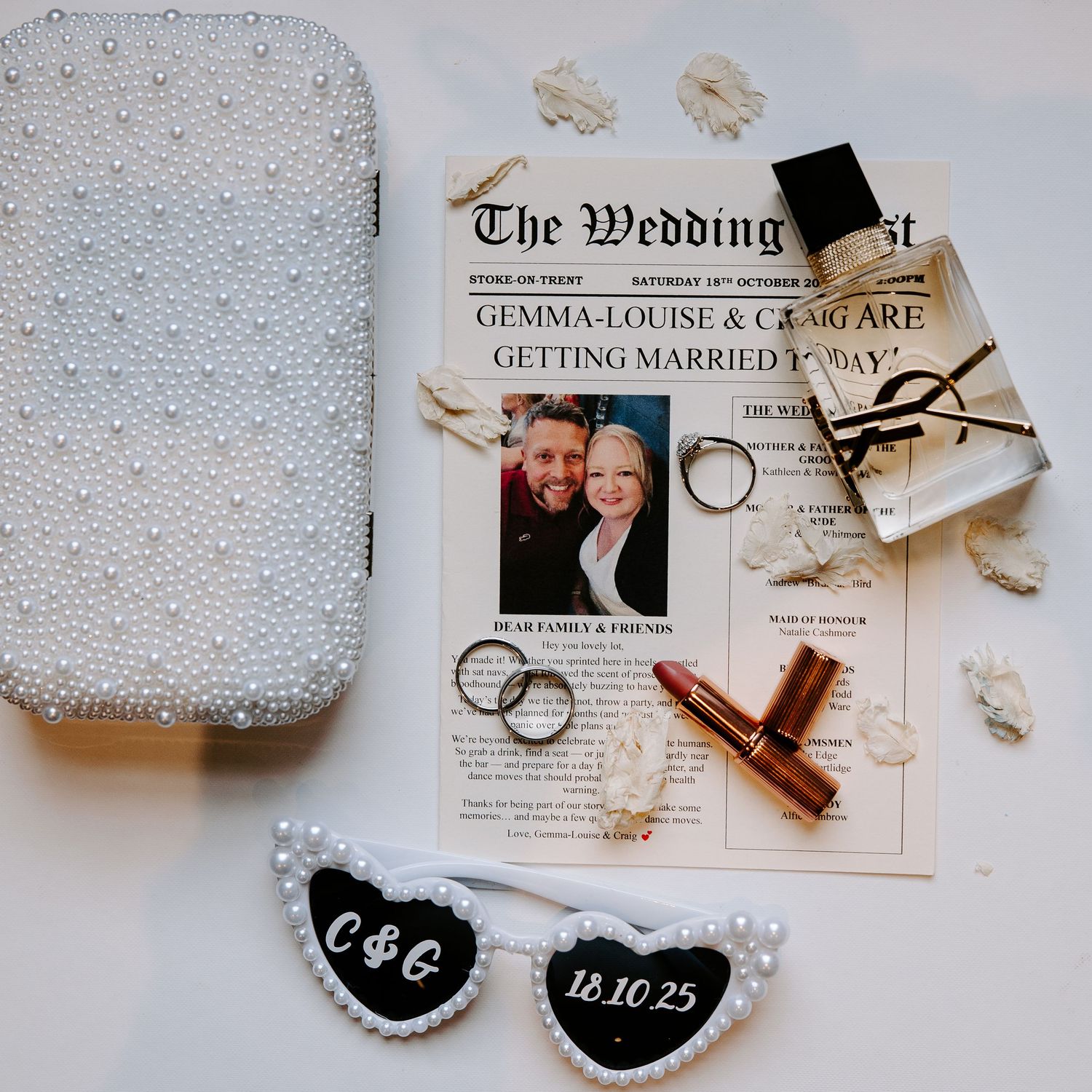 A wedding ring box and invitation details with delicate beaded textures and neutral tones create an elegant flat lay composition.