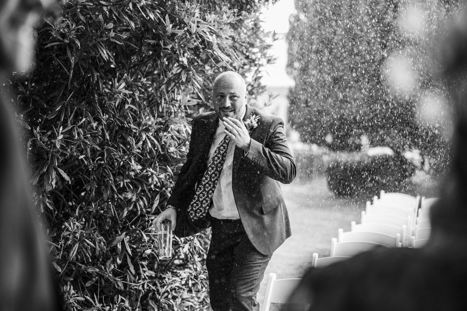 A couple shares an intimate moment in a black and white outdoor wedding photo.