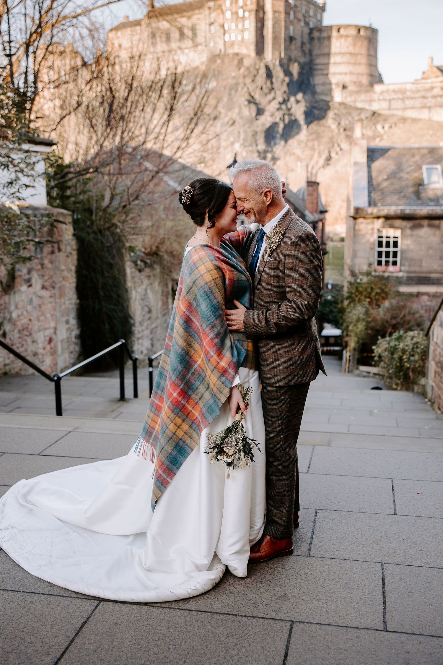 A couple shares tender moments in a sequence of romantic outdoor photos against a stone building backdrop.