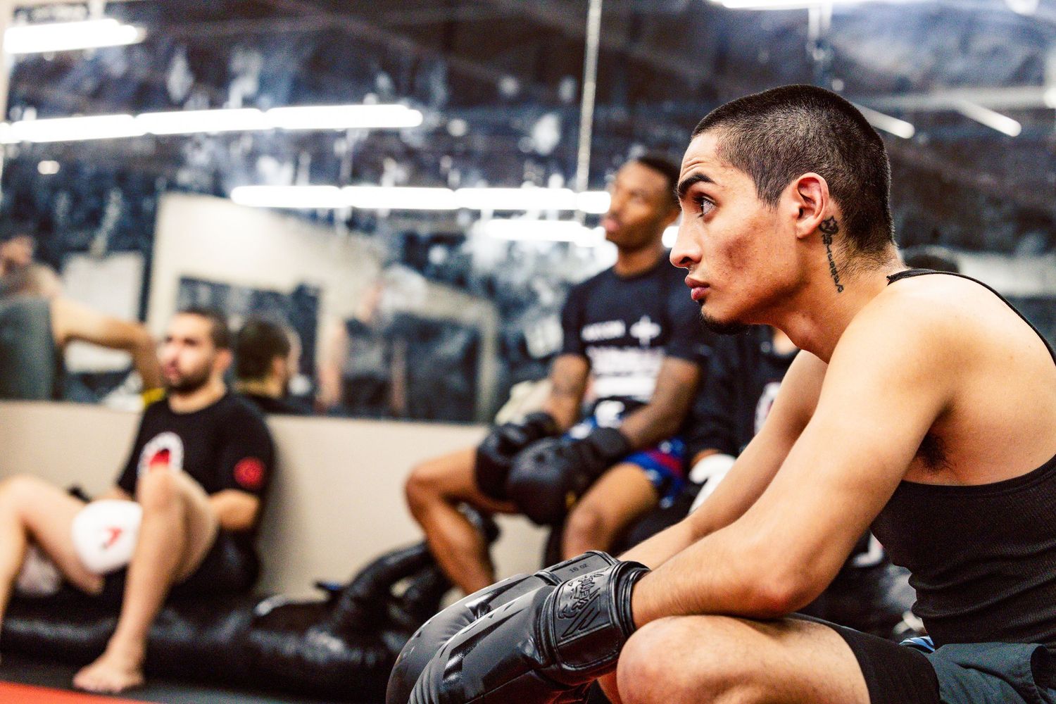 Athletes in a boxing gym watching and learning during a training session.