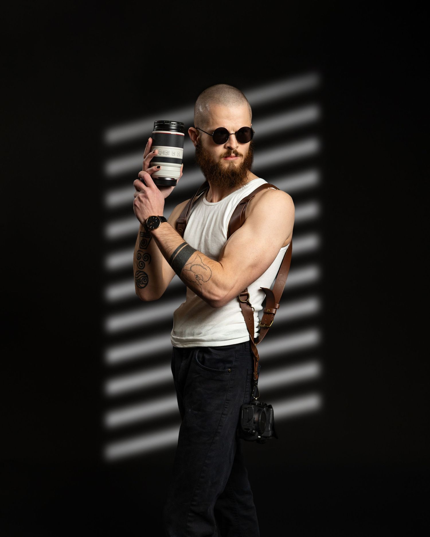 Bearded person in tank top holds coffee cup against dramatic black background with striped lighting effect.