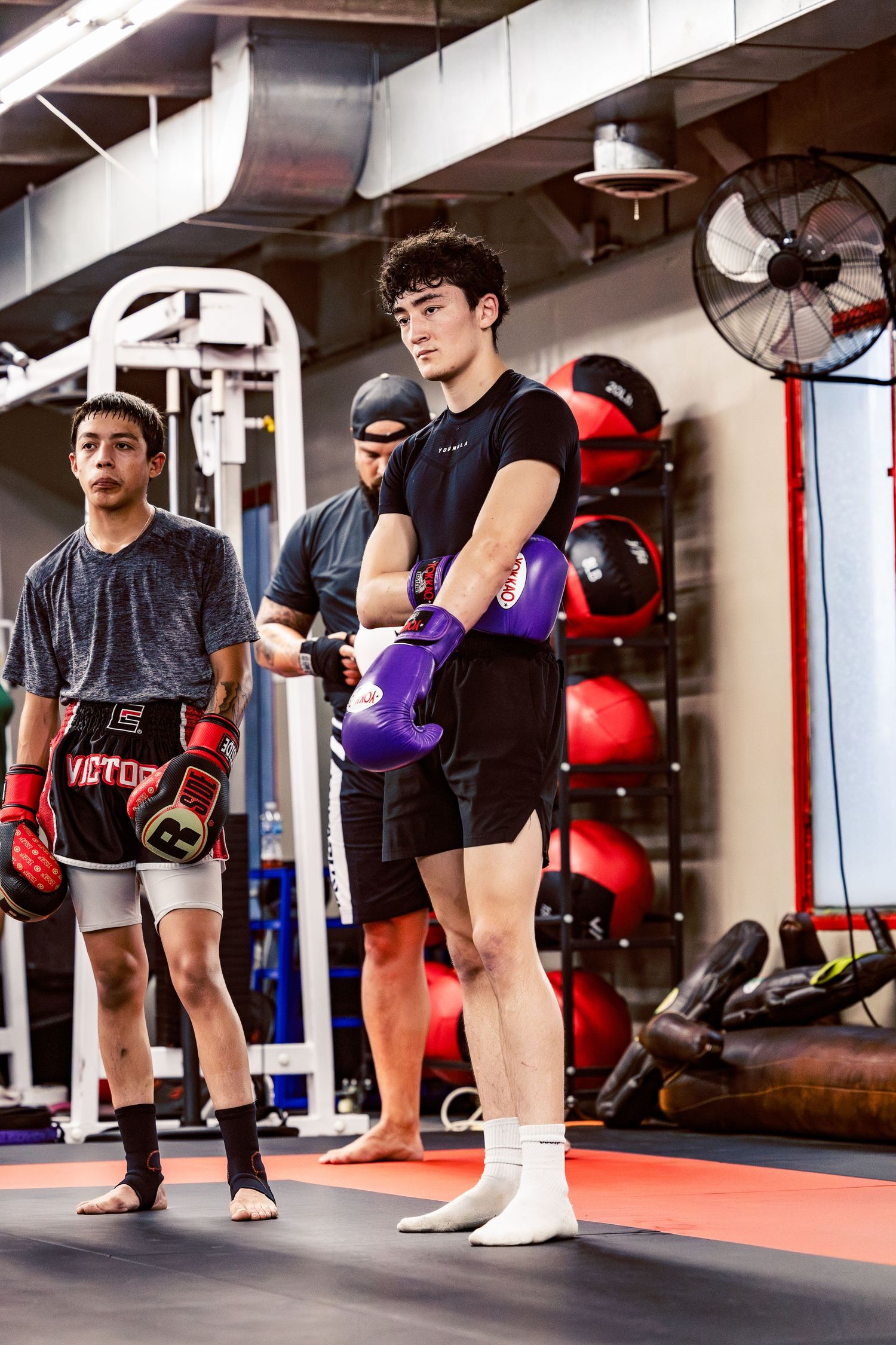 Mixed martial arts students practicing stance and movement drills in the gym.