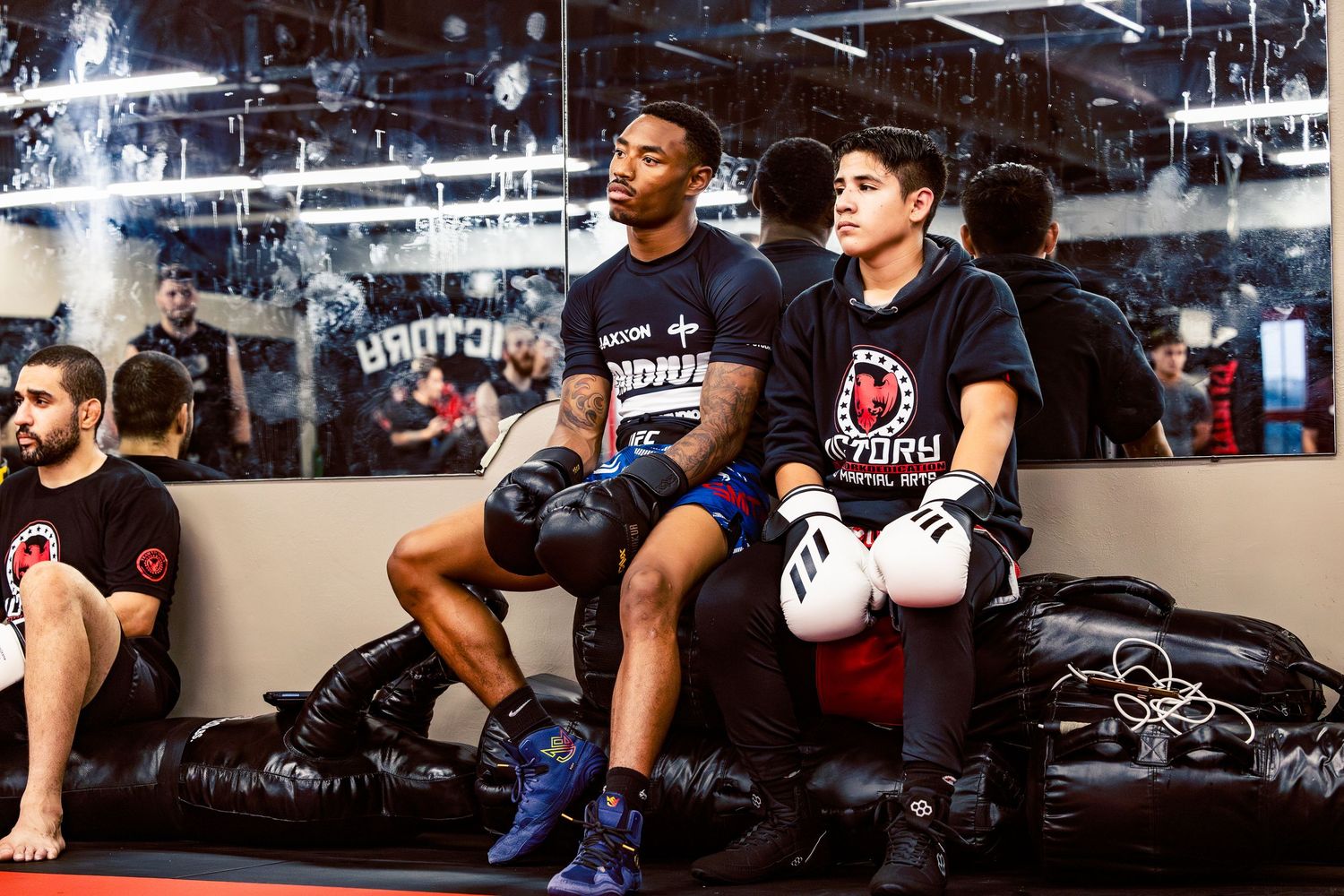 Group of fighters lined up against the wall during a martial arts class.