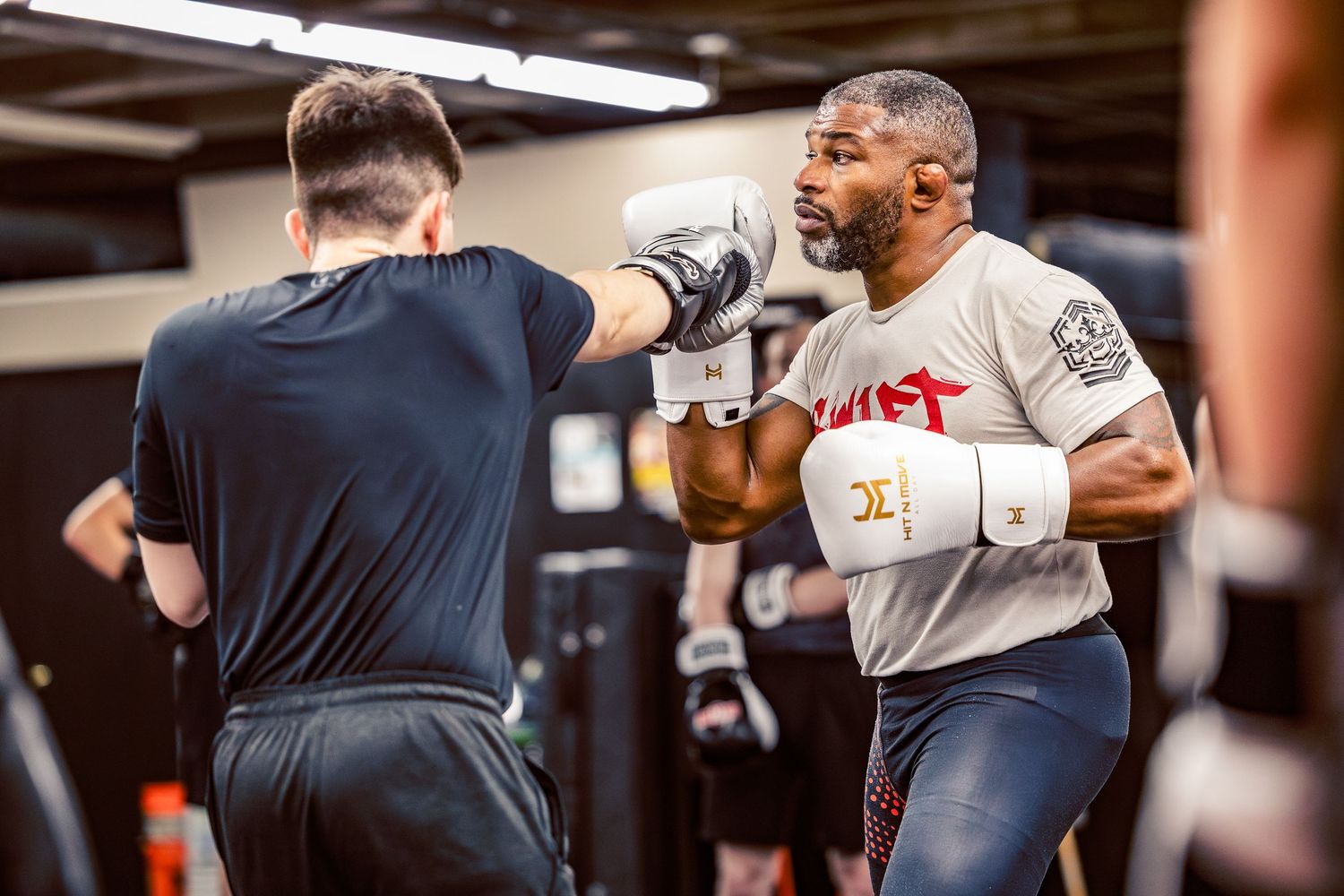 Athletes engaged in partner drills during an intensive boxing training session.