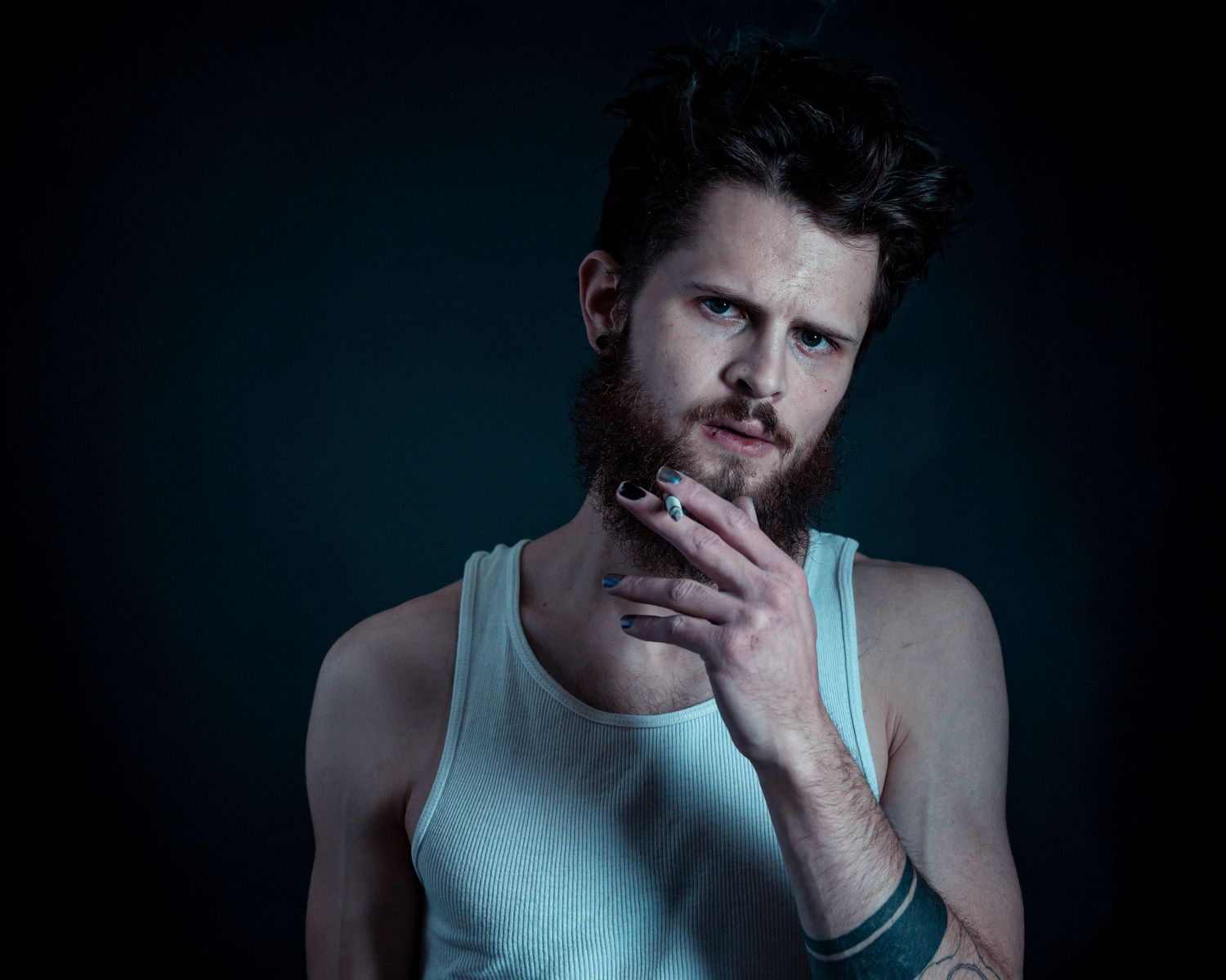 A dramatic portrait series in dark lighting shows a person in a light blue tank top against a moody background.