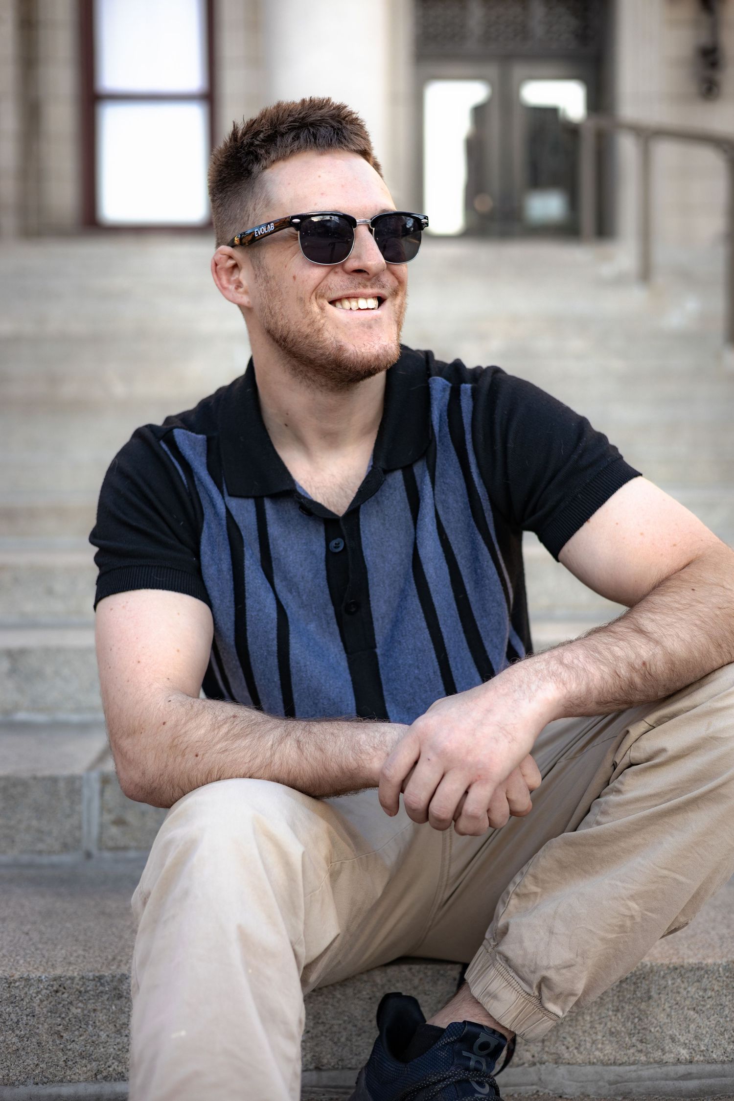 Person in sunglasses and striped vest relaxing on stone steps in various casual poses.