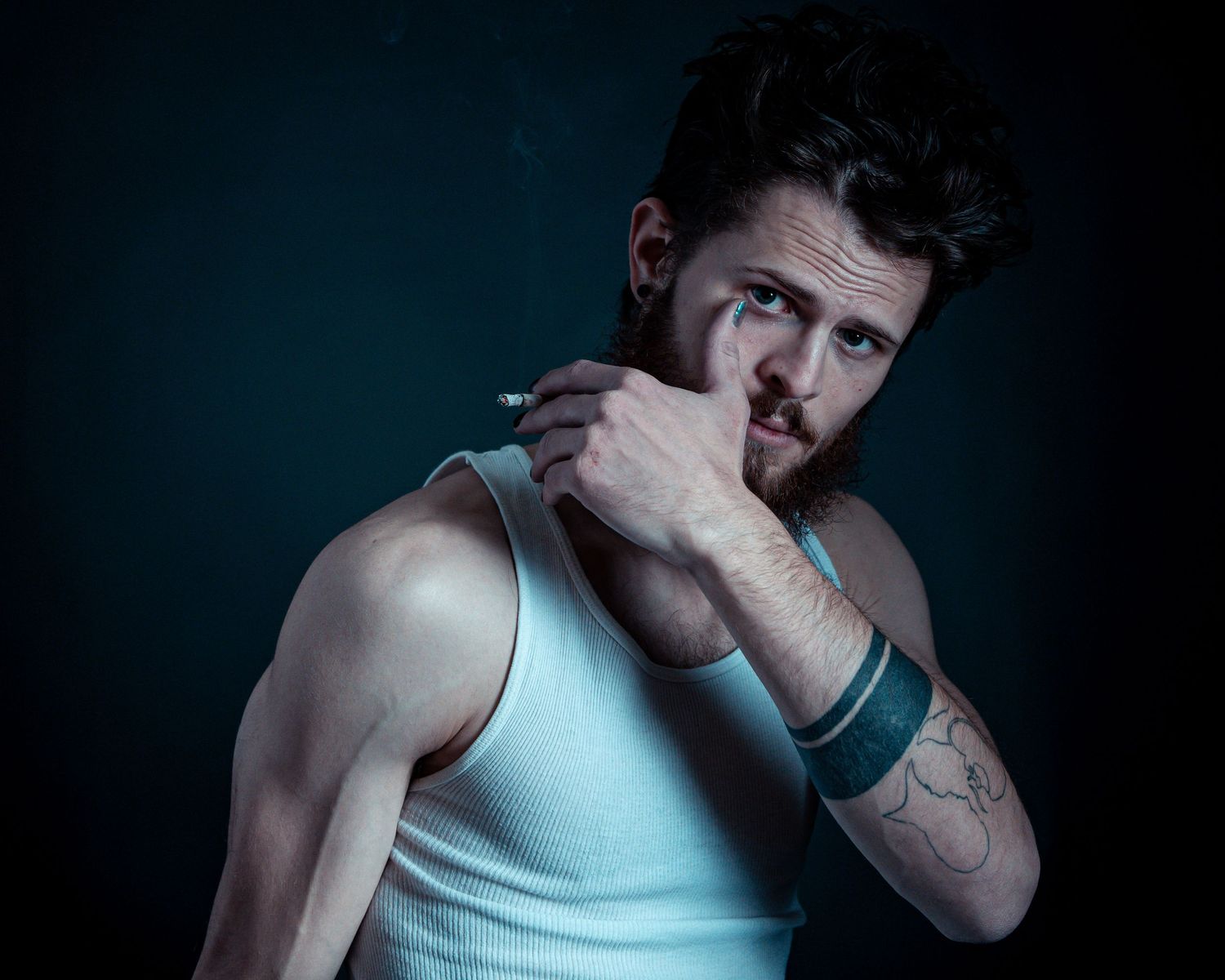Dramatic black and white photo series showing emotional poses against dark background in tank top.