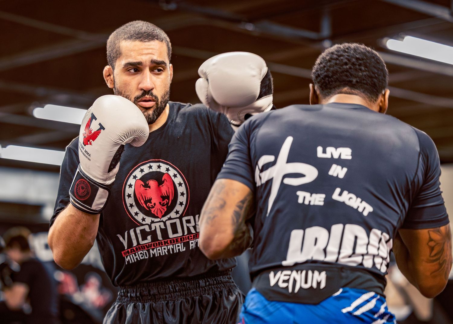 Boxing gym members train together wearing Venum and Victory branded gear.