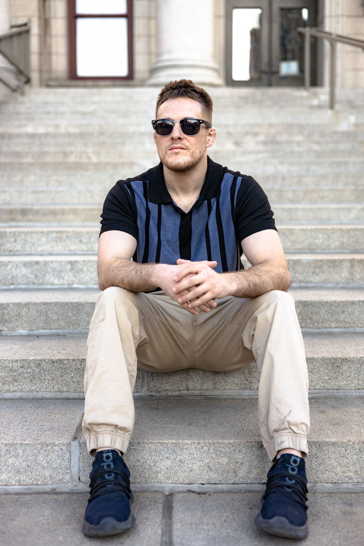 Person sitting on concrete steps wearing sunglasses and casual clothing in multiple poses.