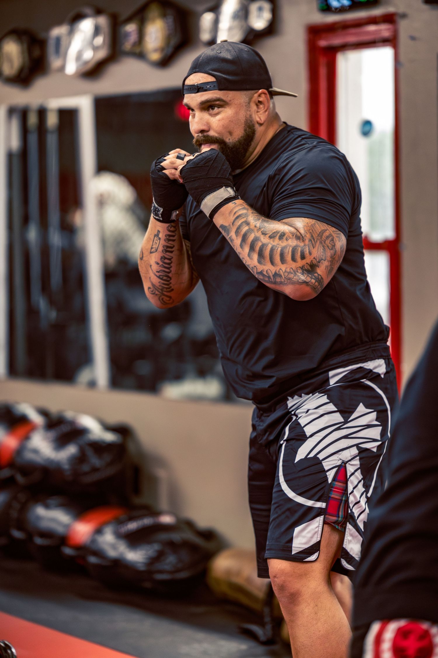 Athletic person in black workout gear demonstrating side lunges during an intense training session.