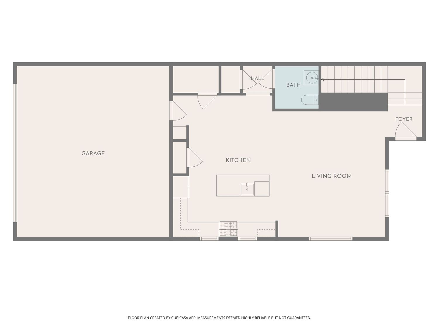 Floor plan showing a garage, kitchen, living room, bath, foyer, and staircase in an open layout home.