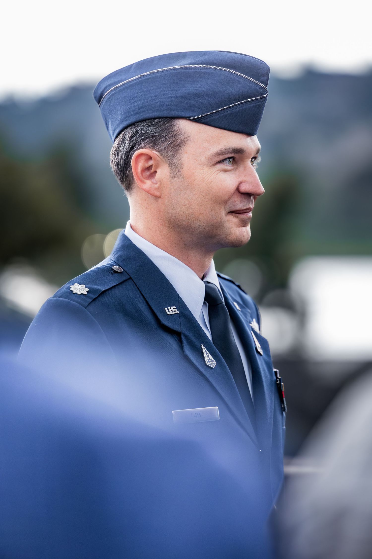 Air Force service members in dress blues participating in formal outdoor event.