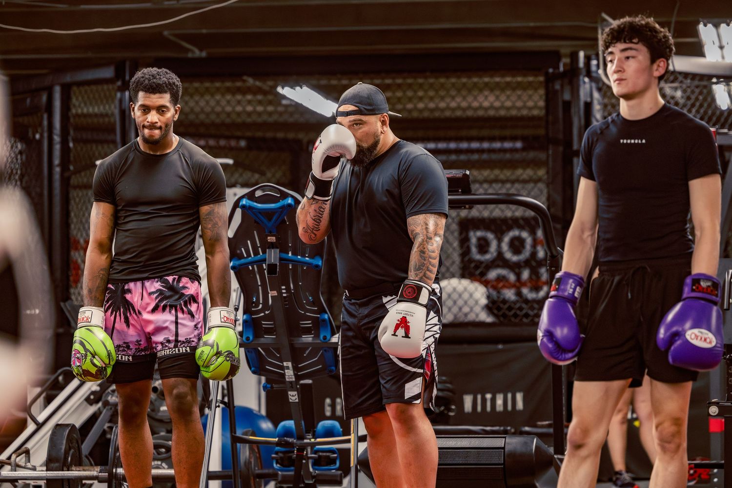 Row of martial arts practitioners training with various colored gloves.