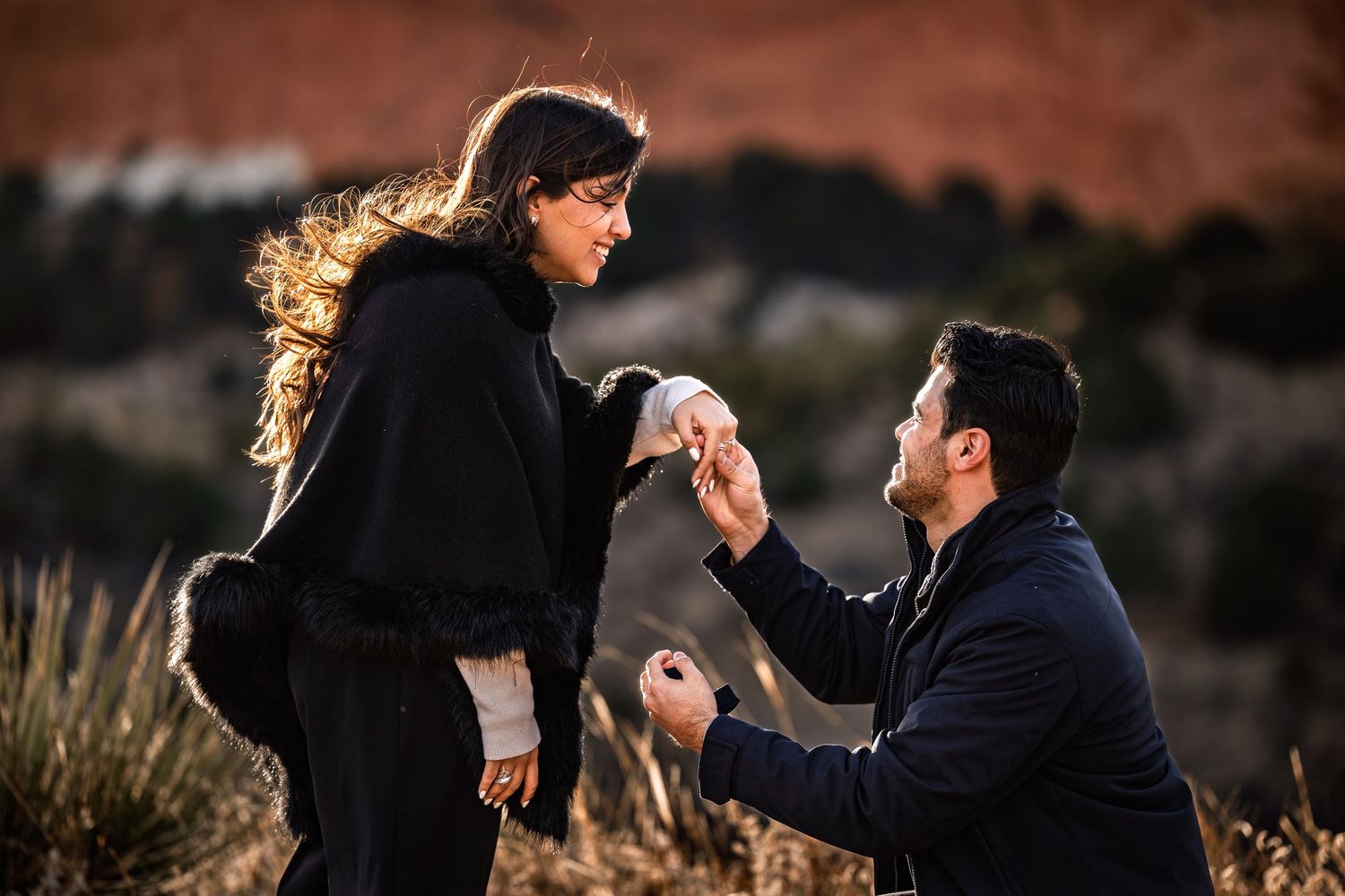 A couple shares a romantic moment during a sunset engagement photo session in a scenic outdoor setting.