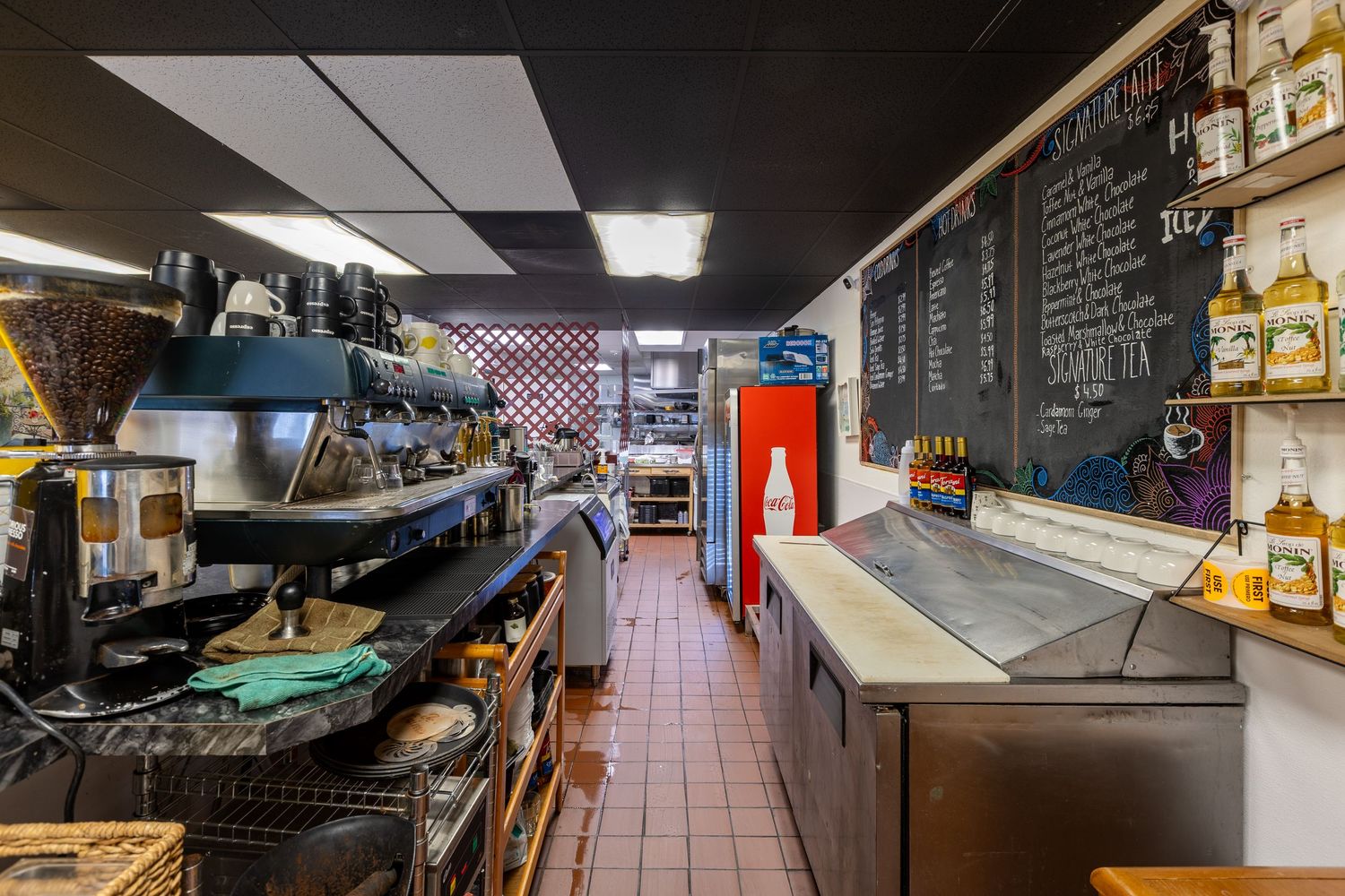 Espresso bar and beverage station with chalkboard drink menu in cafe.