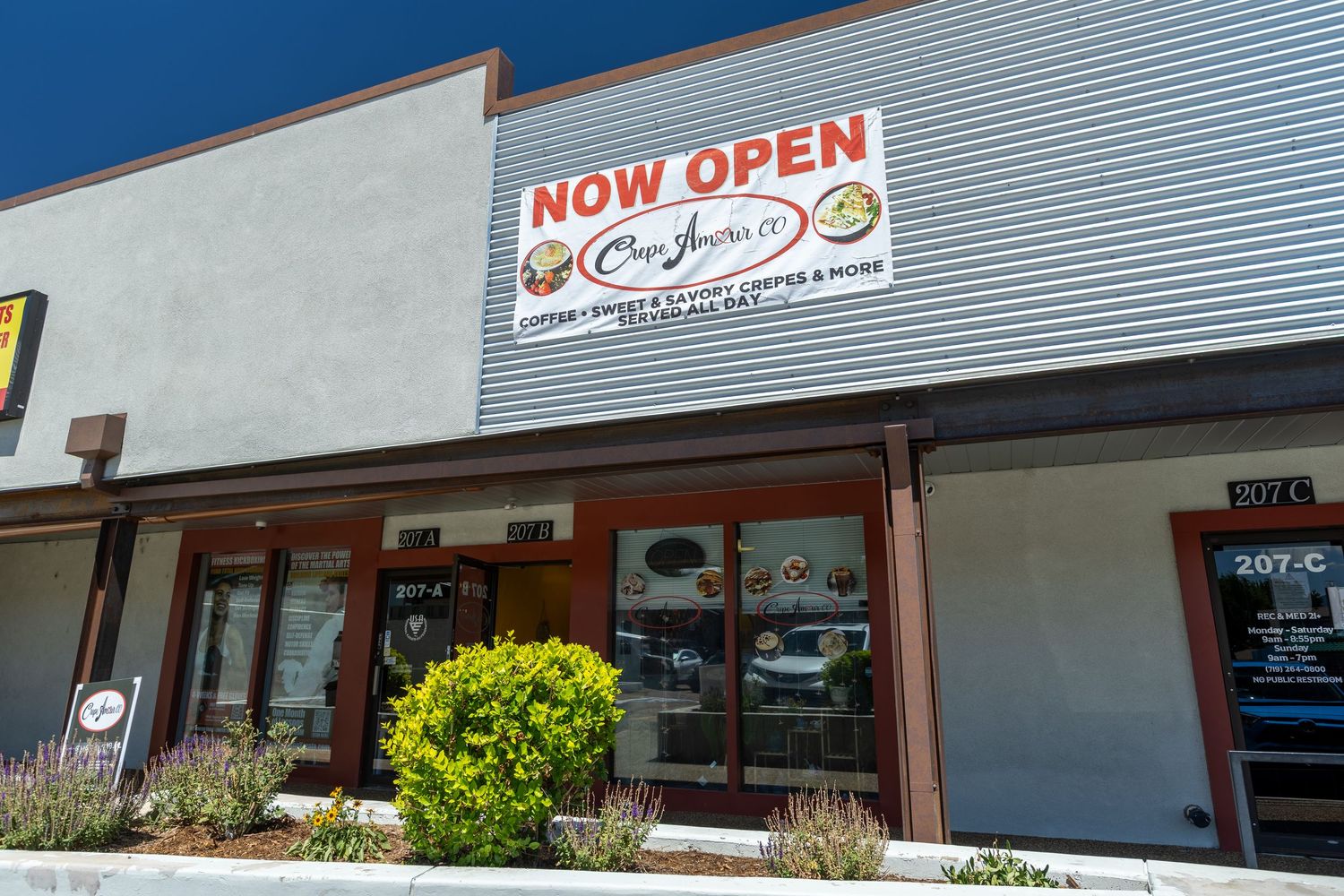 Exterior storefront of a newly opened cafe and crepe restaurant with a bright NOW OPEN banner.