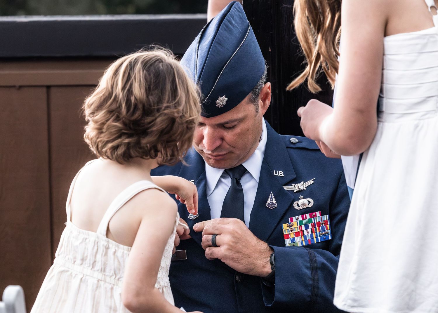 Military ceremony outdoors with service member in dress blues.