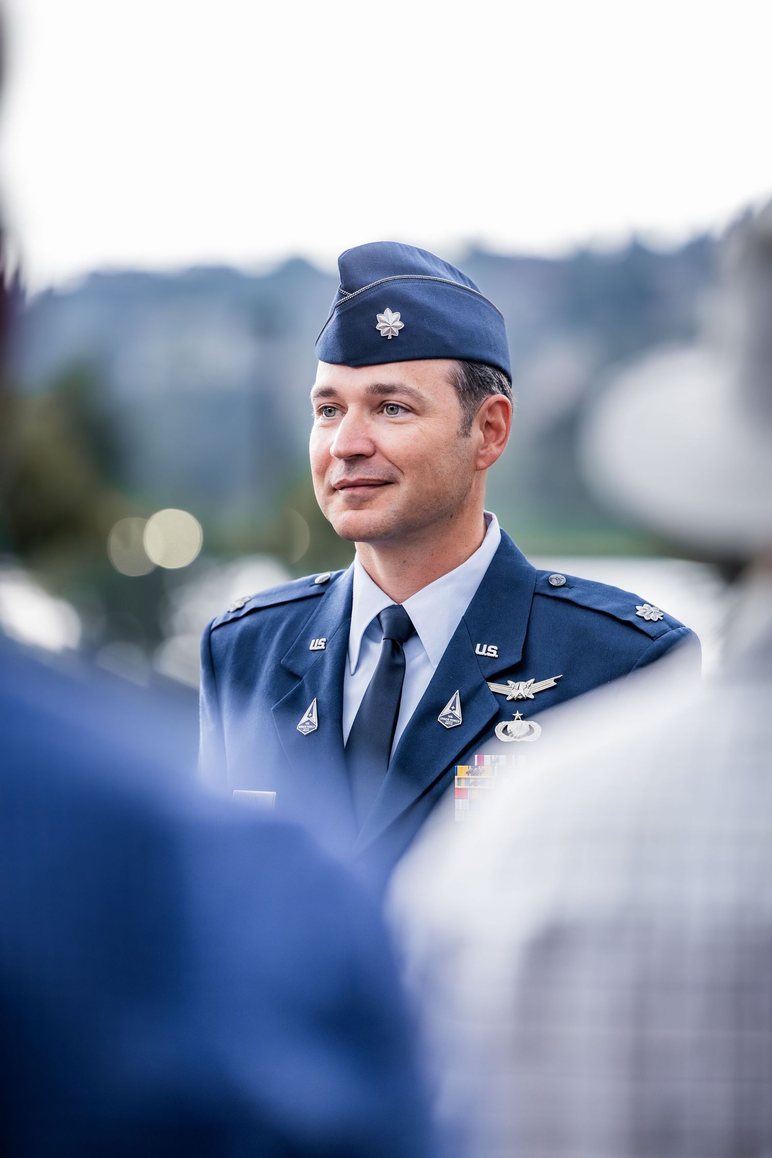 Military personnel in dress blues attending formal outdoor ceremony.