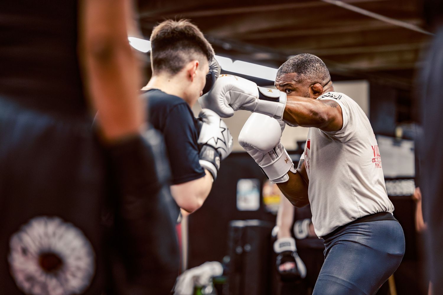 Fighters practicing defensive techniques and blocking drills during combat sports training.