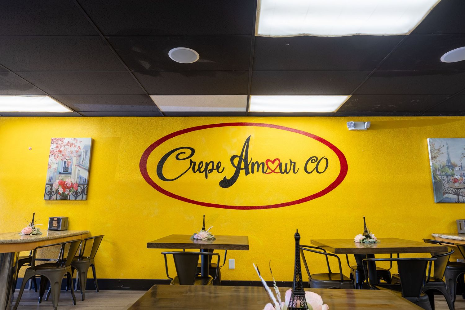 Crepe Amour CO restaurant logo on vibrant yellow wall in dining room.