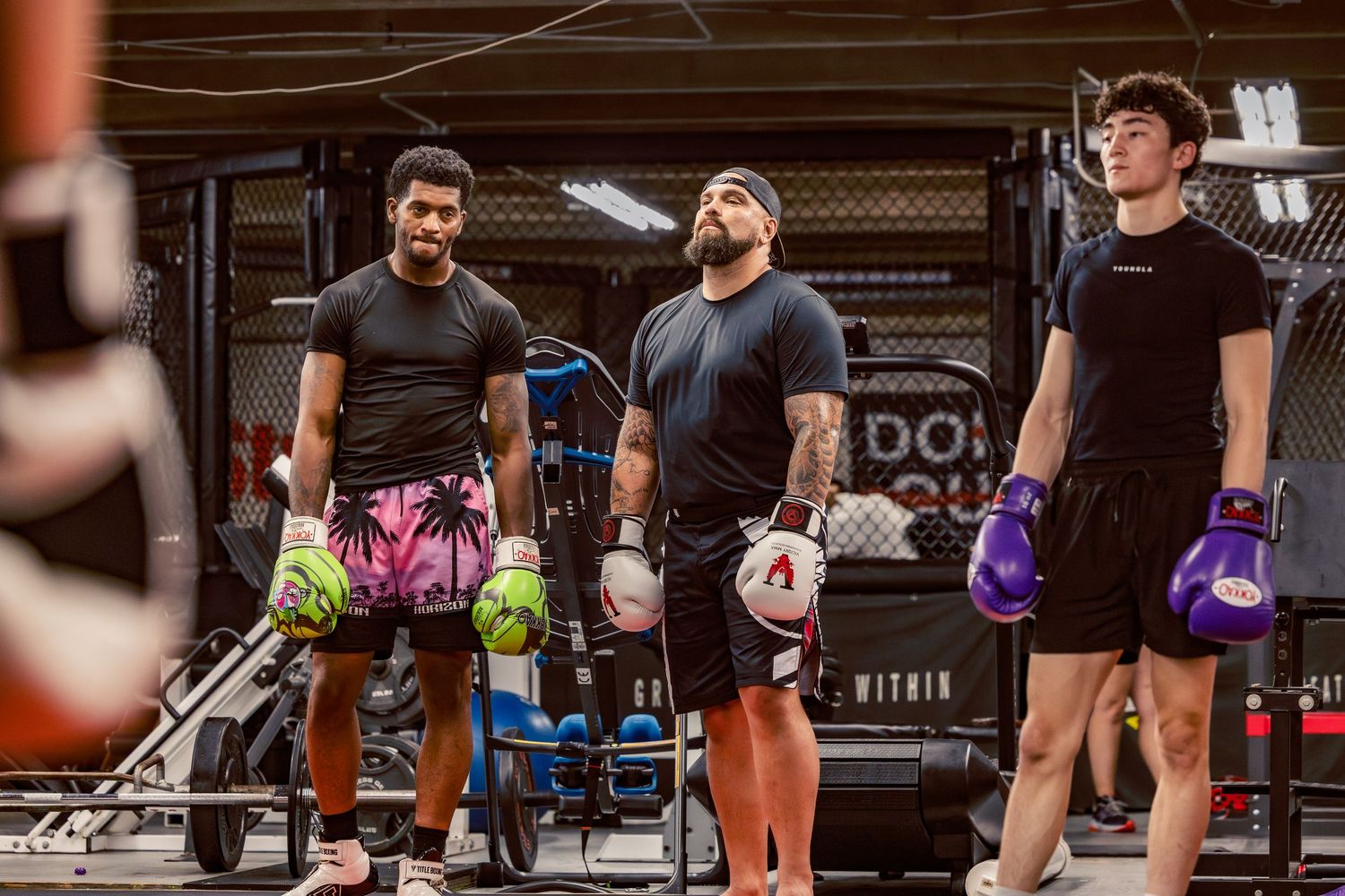 Students lined up during combat sports training session with colored boxing gloves.