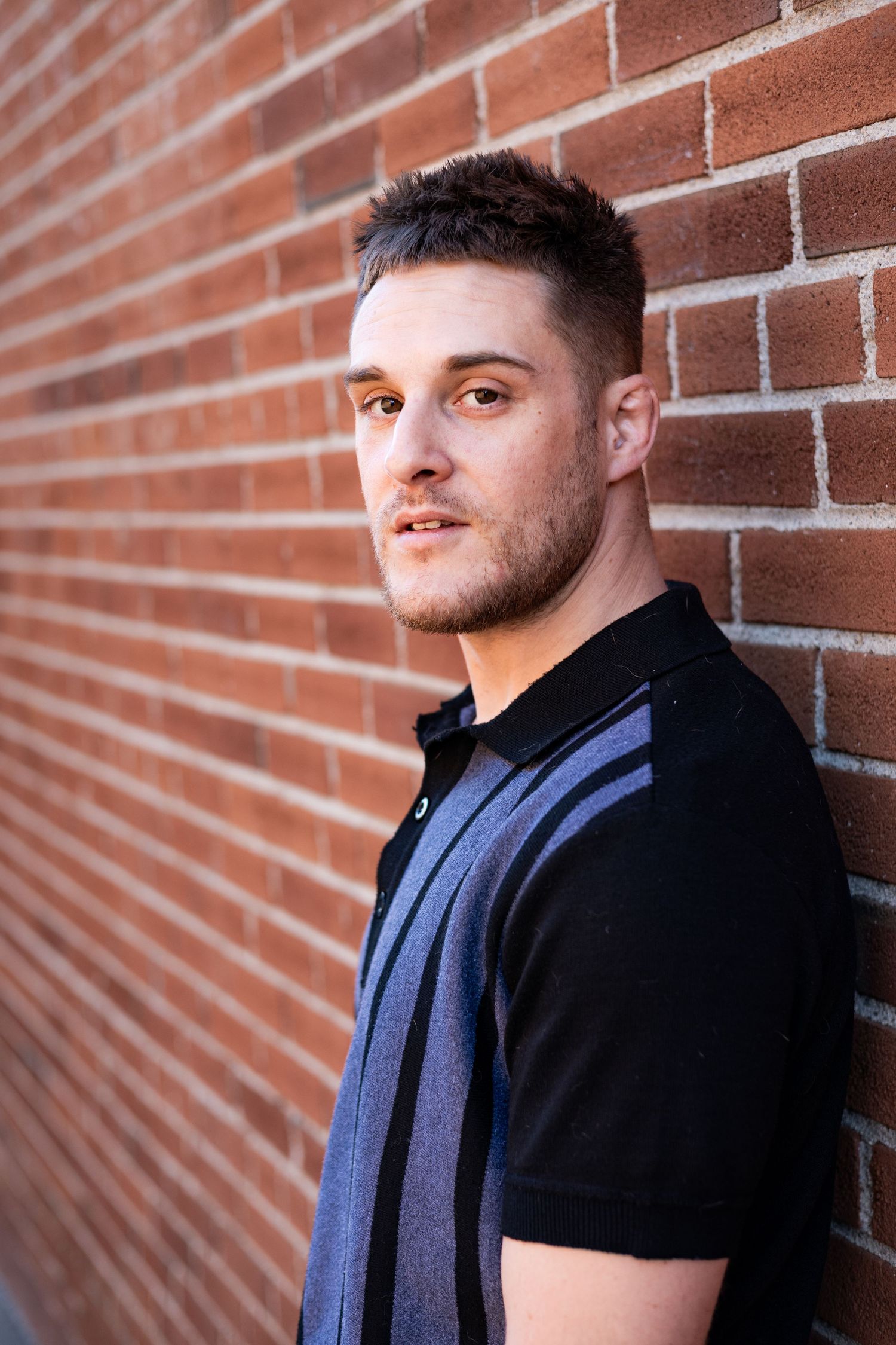 Portrait series against a brick wall showing different poses in casual attire.