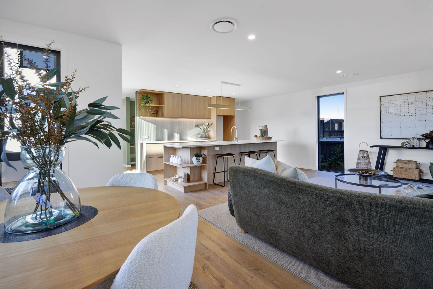 Contemporary living room featuring grey sofa, wooden floors and indoor plants.