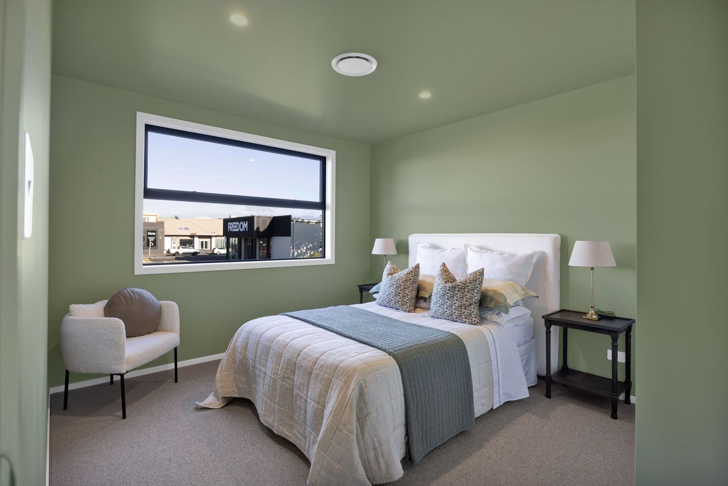 Spacious master bedroom with large windows and neutral color palette.