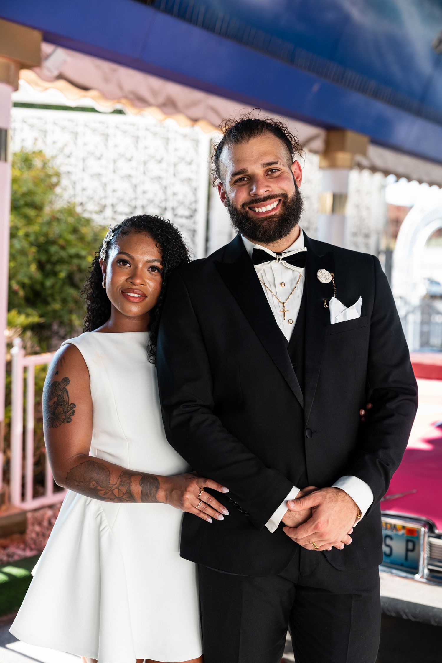 A joyful couple poses together for their wedding photos in formal attire.