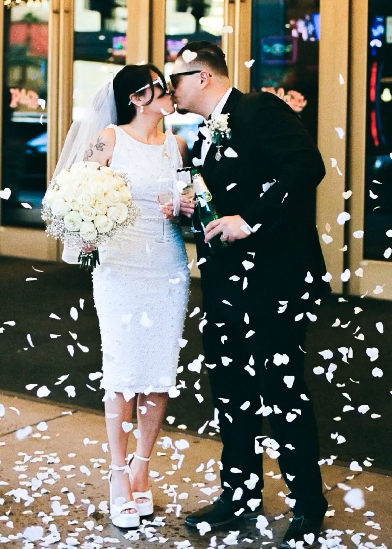 A wedding celebration with flower petals falling around the couple.