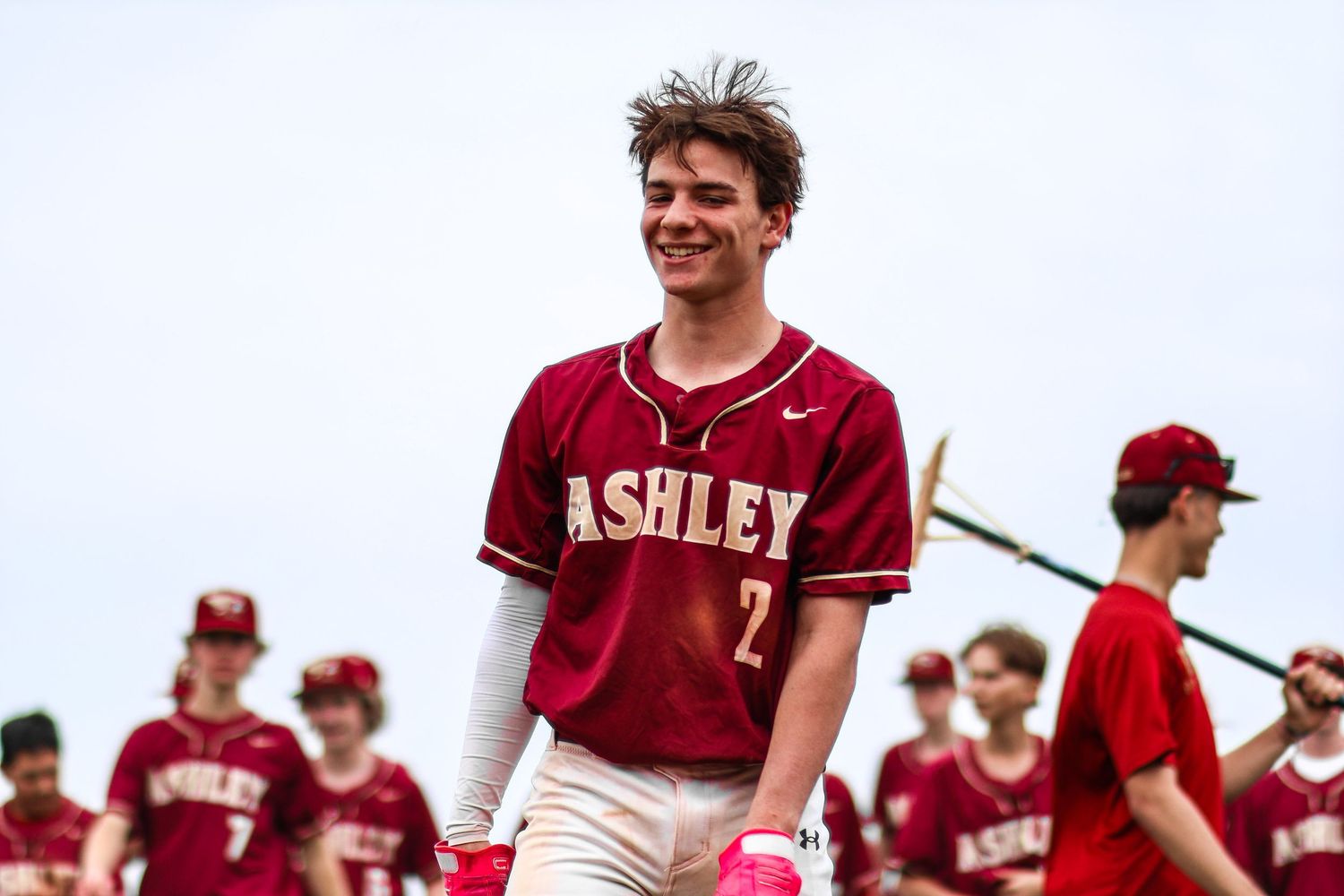 Ashley baseball player number 2 smiling in maroon uniform after game.