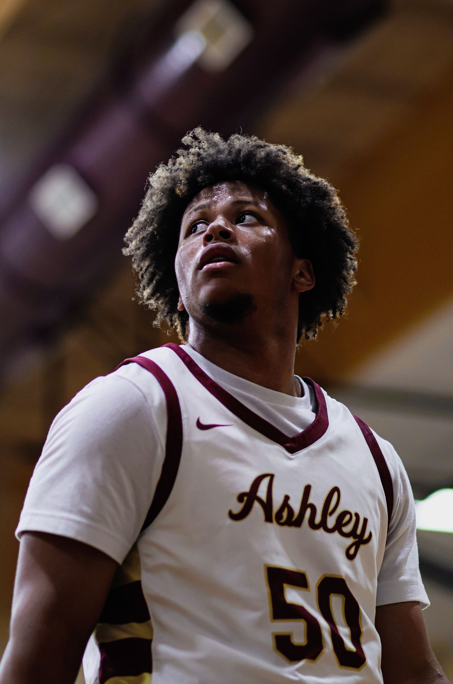 Basketball players in maroon and white uniforms celebrate during a game.